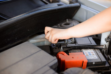 Young girl tries to repair broken car by herself, opening some tank with oil