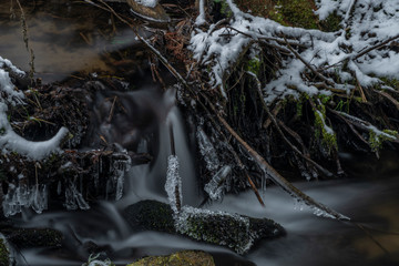 Hodslavsky creek with snow and ice in snowy winter day in Sumava national park