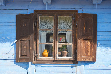 Old wooden peasant thatched farmhouse with decorative shutters