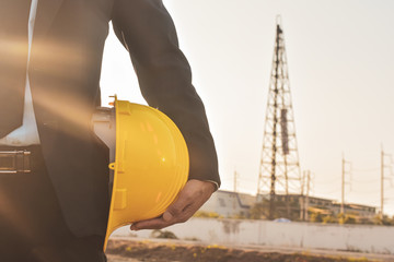 Close up project manager holding helmet hard hat construction building background