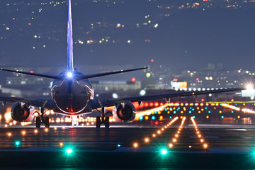 夜の滑走路で離陸する旅客機