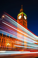 Light trails left by double decker bus passing by Big Ben in London England United Kingdom UK