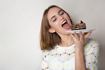 Pleased girl bites yummy cake