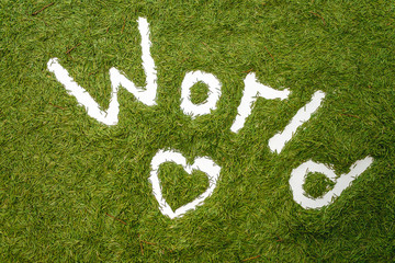 The word WORLD. Pine needle lining. Ecology concept. Hands draw. Image on a green background.