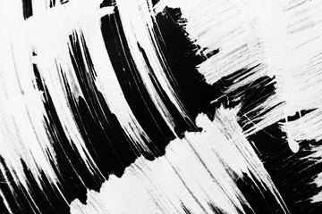 Patterns of white paint from a brush on a black background