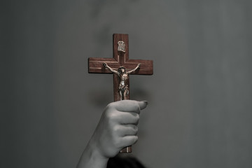 A female hand holds a crucifix. Crucifix in the hand. The concept of exorcism