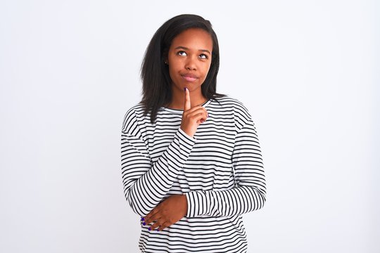 Beautiful young african american woman wearing winter sweater over isolated background Thinking concentrated about doubt with finger on chin and looking up wondering