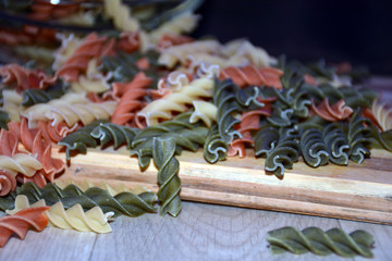 Multi-colored pasta on a wooden board. Food.