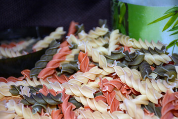 Multi-colored pasta on a wooden board. Food.