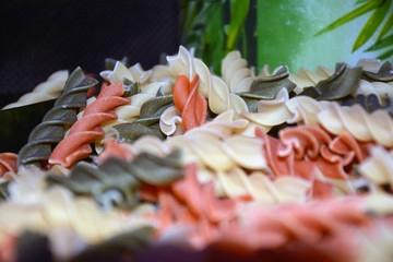 Multi-colored pasta on a wooden board. Food.