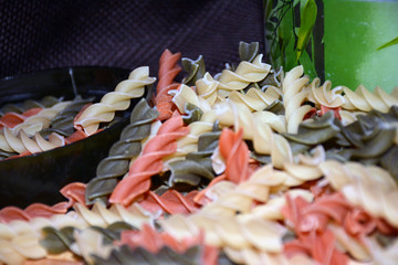 Multi-colored pasta on a wooden board. Food.