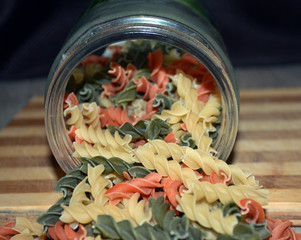 Multi-colored pasta on a wooden board. Food.