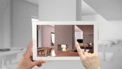 Augmented reality concept. Hand holding tablet with AR application used to simulate furniture and design products in total white unfinished background, cosy kitchen