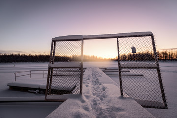 Fototapeta premium The ice lake and forest has covered with heavy snow and nice blue sky in winter season at Holiday Village Kuukiuru, Finland.