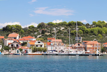 Panorama of a yacht marina in the town of Jezera in Croatia in the Dalmatia region. The ships moored in the port of a quiet fishing town in a sunny, clear day. Tourist marine business. Murter island