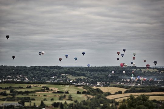 Hot Air Balloons Flying In The Bristol Balloon Fiesta Against Cloudy Sky