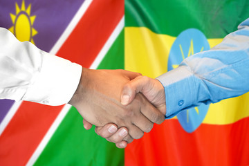 Handshake on Namibia and Ethiopia flag background.