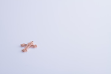 Golden christian cross pendant. White isolated background, copyspace.