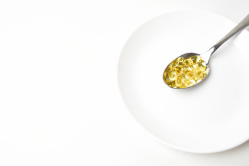 Fish oil capsules in the spoon.