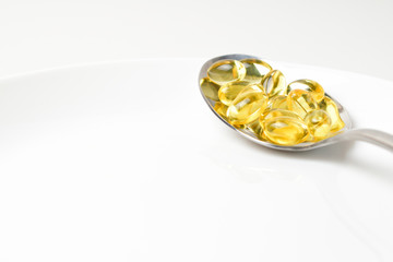 Fish oil capsules in the spoon.