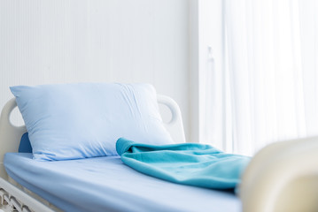 The patient blue bed with bed sheet in the hospital.