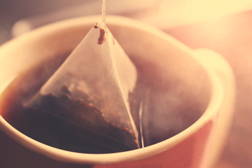 Triangular tea bag in Cup so close, pink toned