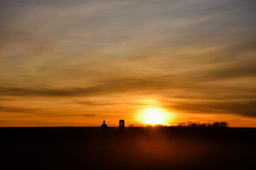 Fototapeta na wymiar silhouette of church on a sunset background, an abandoned church in field at sunset, church on colorful sunset sky