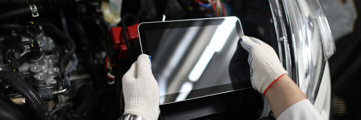 Close-up of special digital tablet used for automobile checkup and fixing damaged car parts....