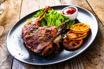 Barbecue chicken thigh with vegetables on wooden background