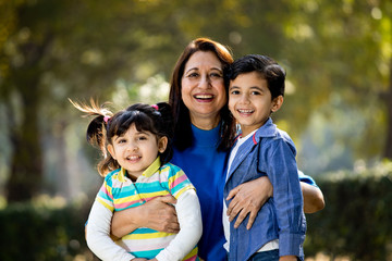 Loving grandmother embracing grandchildren at park outdoor