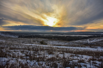 Colorful sunset in the field, winter sunset, orange bright sunset in the winter field