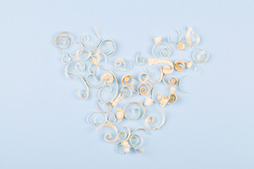 heart from wood shavings on blue background, concept for valentine's day