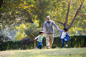 Grandfather playing with grandchildren at park