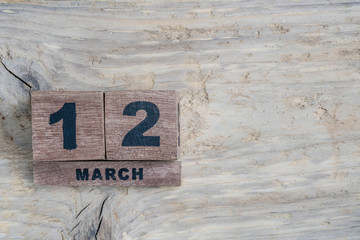 cube calendar for march on wooden background with copy space
