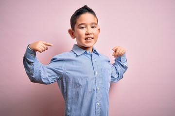 Young little boy kid wearing elegant shirt standing over pink isolated background looking confident...
