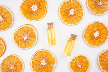 Aroma essential oil in bottles, dried oranges frame on white background. Spa, beauty, healthcare concept. Top view, flat lay, copy space
