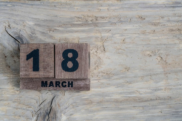 cube calendar for march on wooden background with copy space