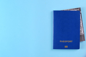 Blue external passport with airplane ticket inside on the bright blue background. Photo with a copy space