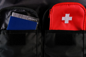 External passport with airplane ticket inside and tourists first aid kit in the pockets of the...
