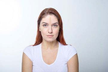 Fototapeta premium Portrait of a redhead woman with tapes on skin color face for rejuvenation. An alternative way to fight wrinkles.