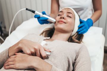 Naklejka premium Facial beauty treatment of beautiful young woman with oxygen at cosmetic beauty salon.