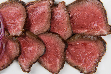 Plate with meat cutting and fresh greens on white plate