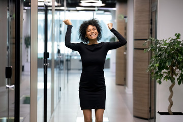 Overjoyed young african american lady celebrating personal business achievement.