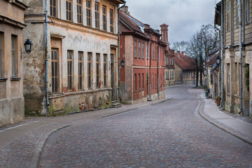 Old city street with old stone and wooden facades and stone paving road