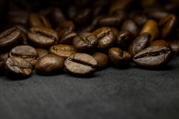 Coffee in beans on dark background. Abstract background texture.Coffee beans texture. Food background of coffee beans