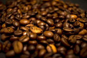 Dark background and texture of coffee beans, selective focus, closeup grains.