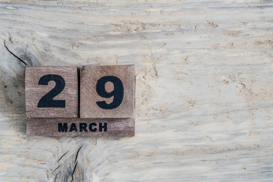 cube calendar for march on wooden background with copy space