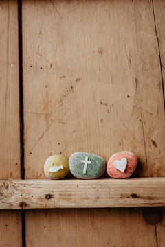 Kommunion, Konfirmation, Firmung, Taufe - bunte Steine mit Kreuz, Fisch und Herz auf Holz