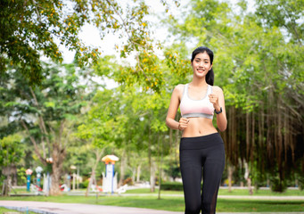 Asian women wear costumes for exercise and jacket running in the park,Asian women are practicing to run a marathon or cardio to lose weight Sport and healthy concept with park background.