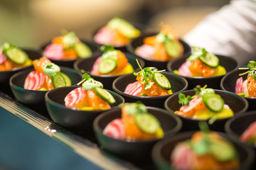 Mini sushi bowls being served on a plate